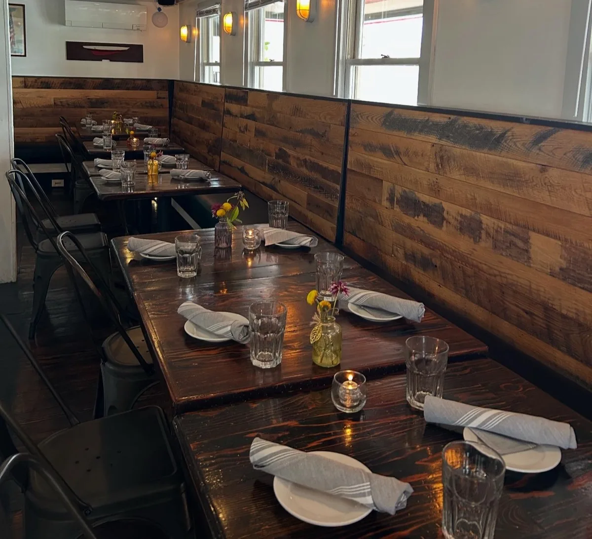 Warmly lit interior dining room with reclaimed wood walls and candlelit tables